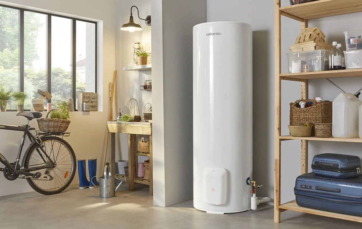 Chauffe-eau électrique blanc installé dans un garage organisé avec rangements en bois