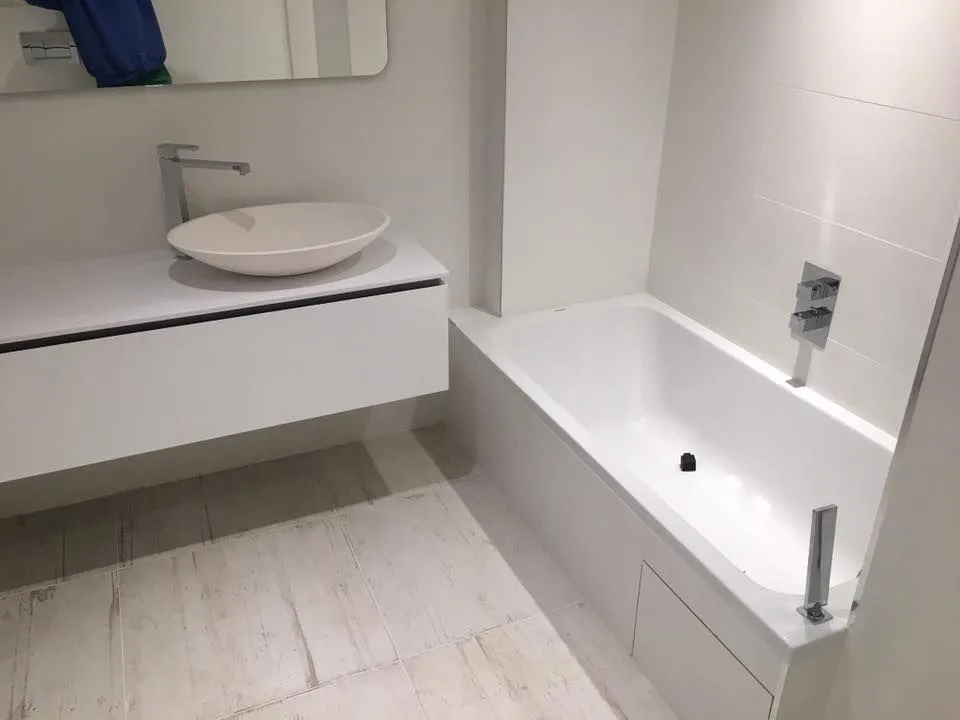 Salle de bains rénovée toute blanche avec meuble vasque suspendu et vasque ovale à poser