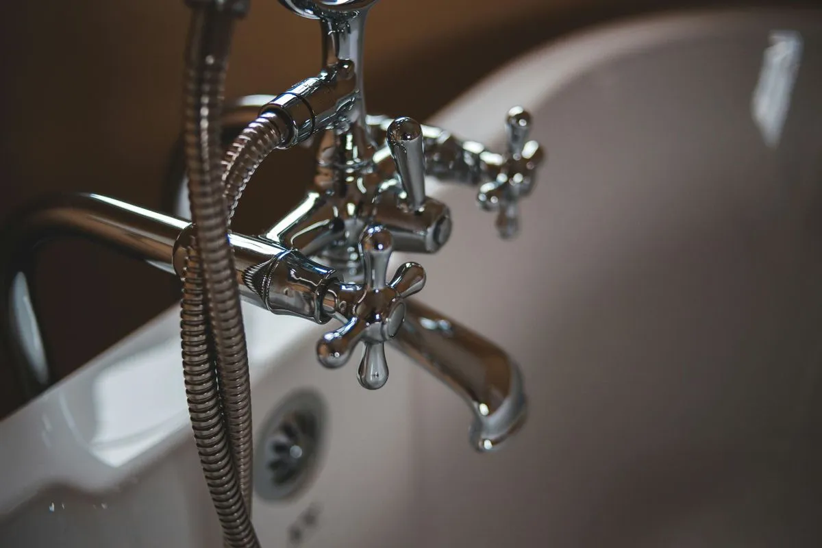 Robinetterie chromée de style rétro avec mitigeur à croisillons et flexible de douche