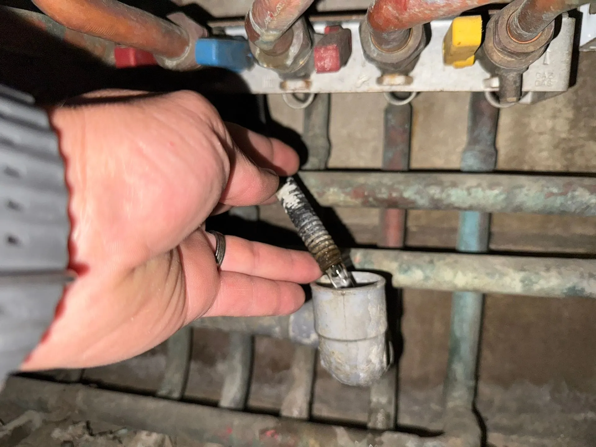 Technicien tenant une tige près d'un collecteur de cuivre pendant une recherche de fuite